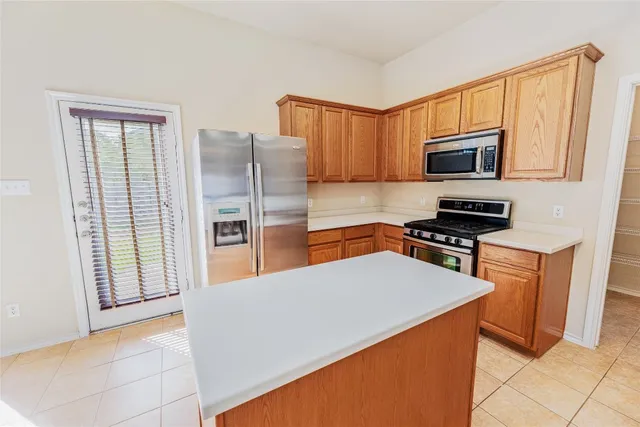 a kitchen with stainless steel appliances a refrigerator stove top oven and sink
