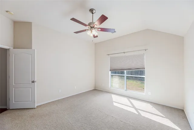 an empty room with closet and a ceiling fan