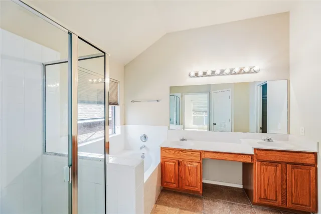 a bathroom with a double vanity sink mirror and bathtub