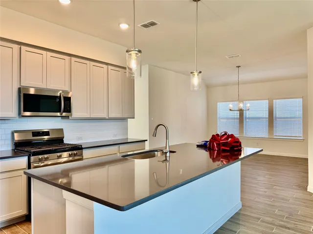 a kitchen with stainless steel appliances a sink a stove and a microwave