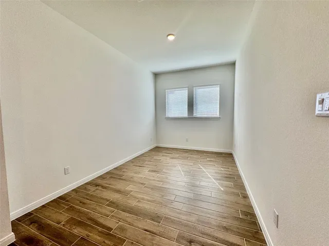 a view of empty room with wooden floor
