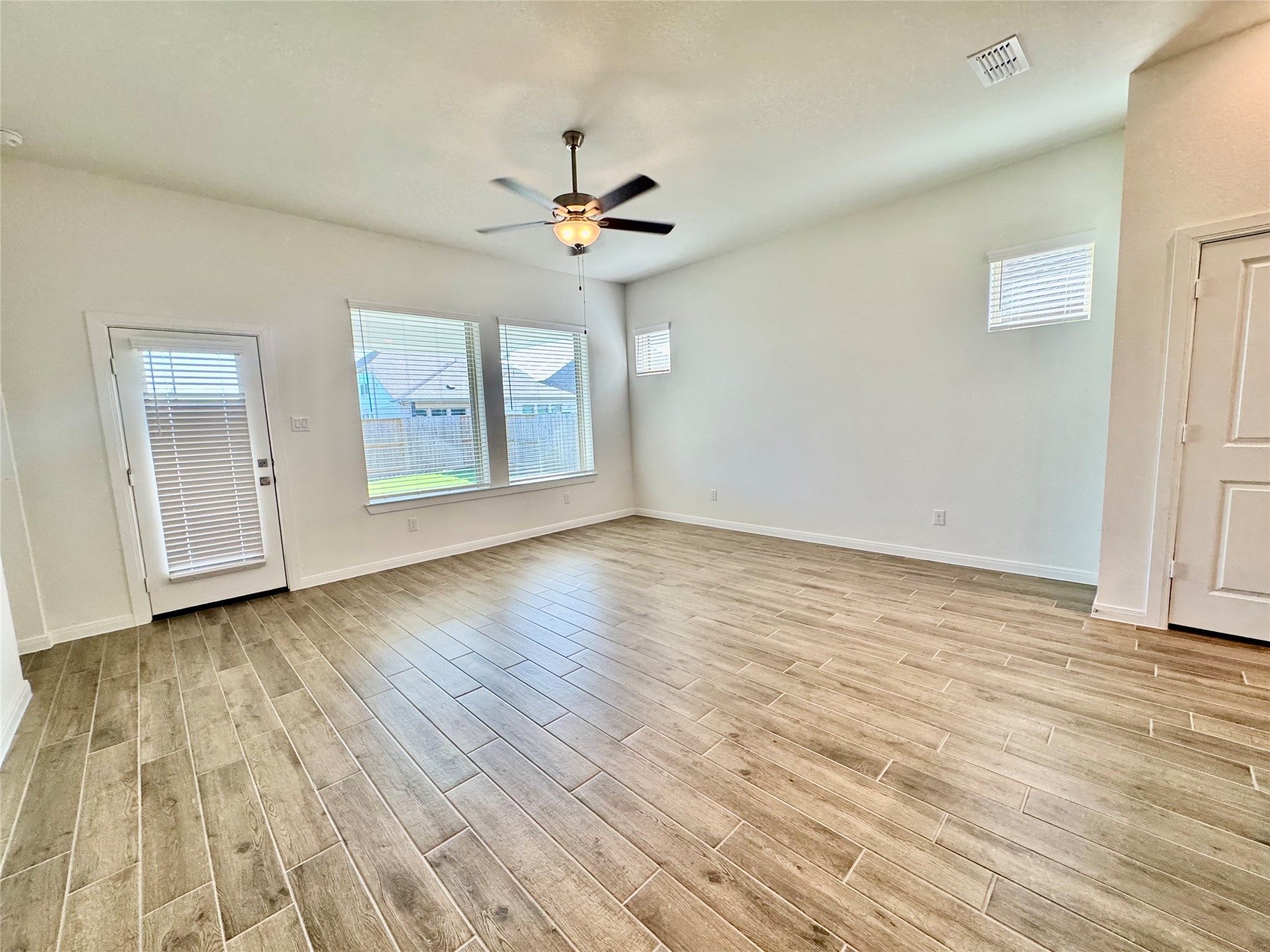 8923 Moose Trail Manvel, TX 77578 - Photo 10 of 20 an empty room with wooden floor chandelier fan and windows