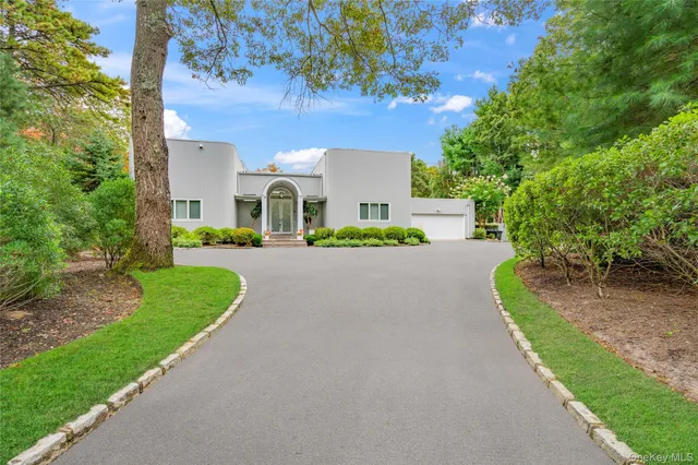 a front view of a house with a yard and trees