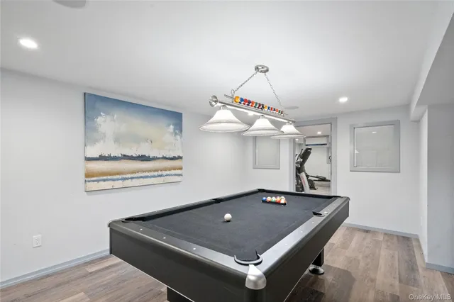a room with pool table and wooden floor