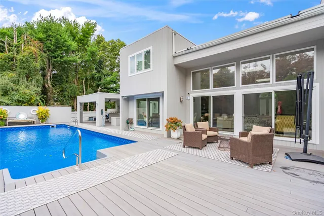 a view of a house with swimming pool and sitting space