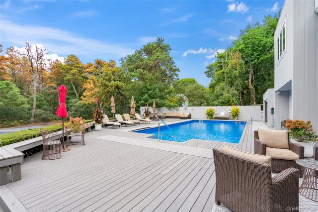 a view of a patio with swimming pool and sitting area