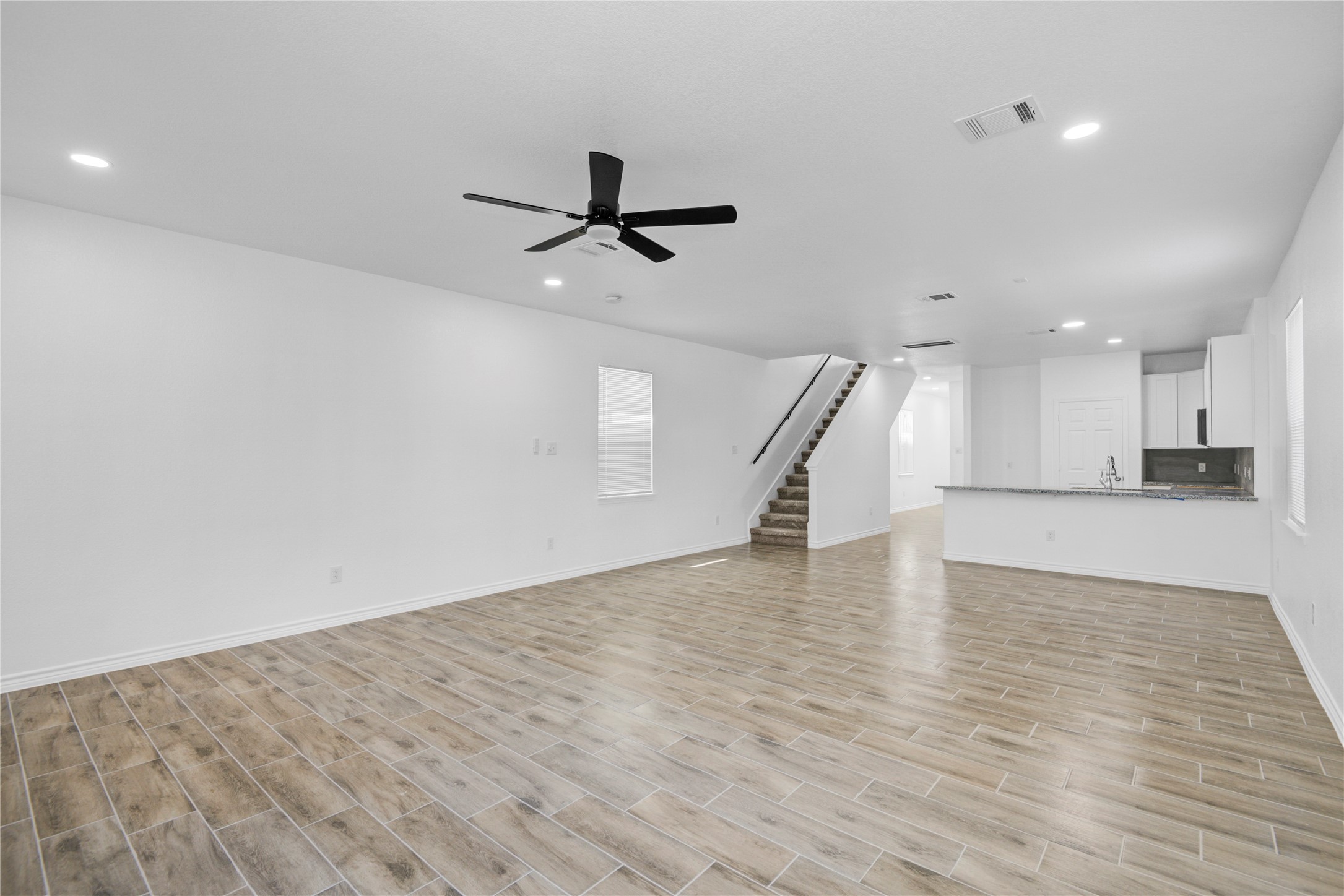 9932 Fillmore Street Houston, TX 77029 - Photo 12 of 27 a view of an empty room with wooden floor and a ceiling fan