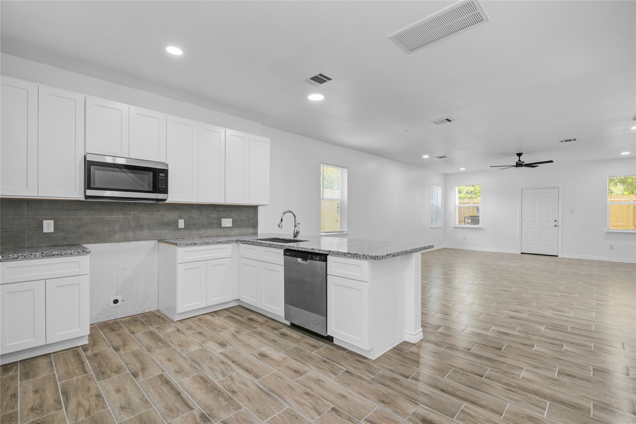 9932 Fillmore Street Houston, TX 77029 - Photo 7 of 27 a large kitchen with cabinets wooden floor and stainless steel appliances
