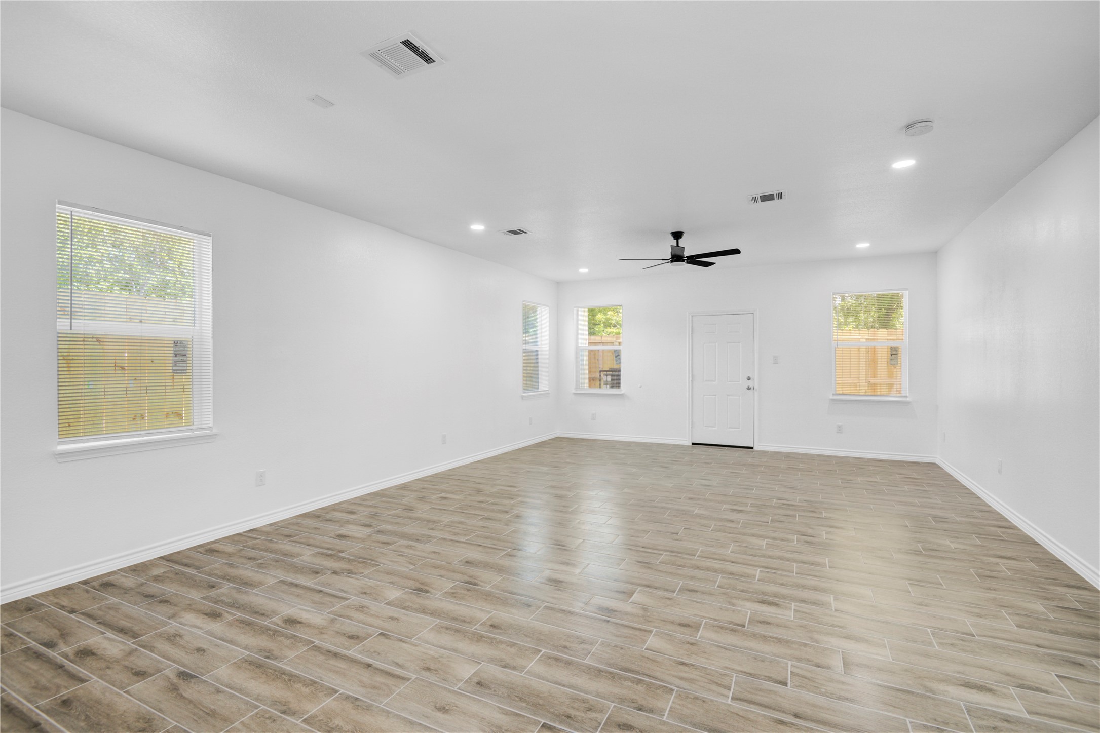 9932 Fillmore Street Houston, TX 77029 - Photo 10 of 27 an empty room with wooden floor and windows
