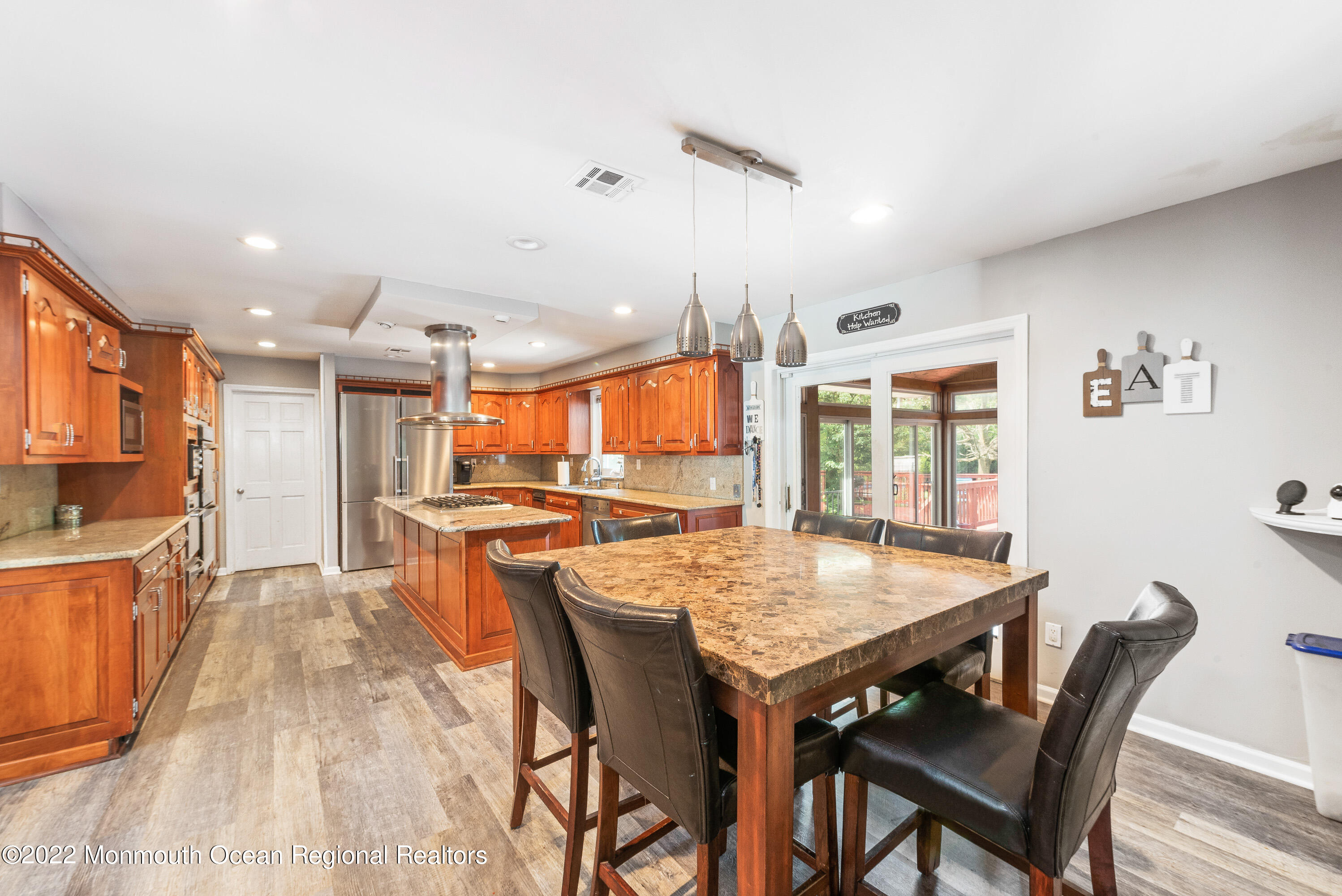 161 Thompson Grove Road Manalapan, NJ 07726 - Photo 5 of 27 a dining hall with stainless steel appliances granite countertop a dining table and chairs with wooden floor