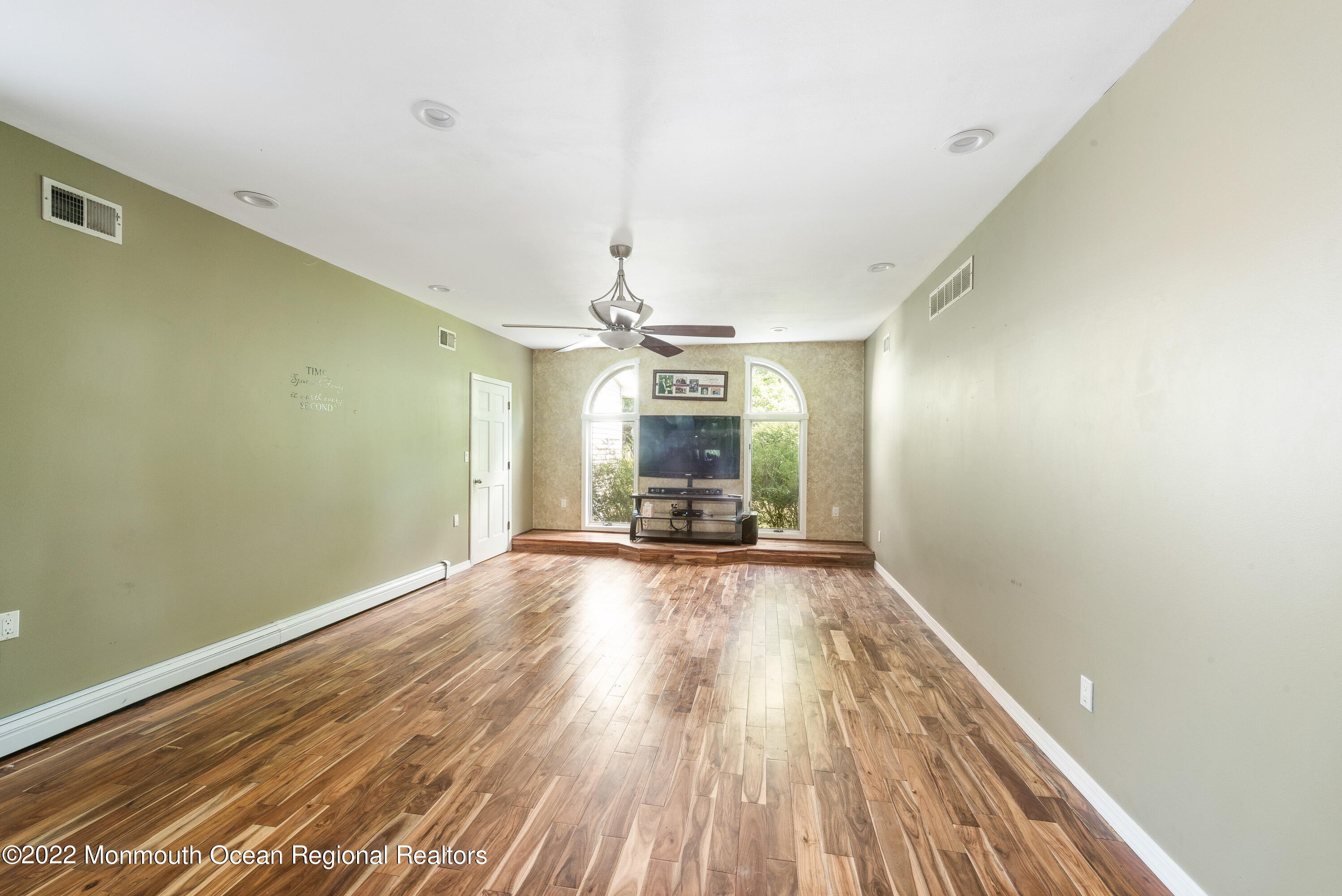 161 Thompson Grove Road Manalapan, NJ 07726 - Photo 7 of 27 a view of a livingroom with wooden floor and a ceiling fan