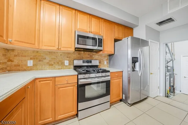 a kitchen with stainless steel appliances granite countertop a refrigerator stove and sink
