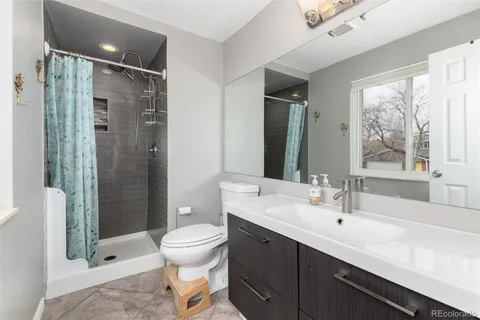 a bathroom with a double vanity sink toilet and shower