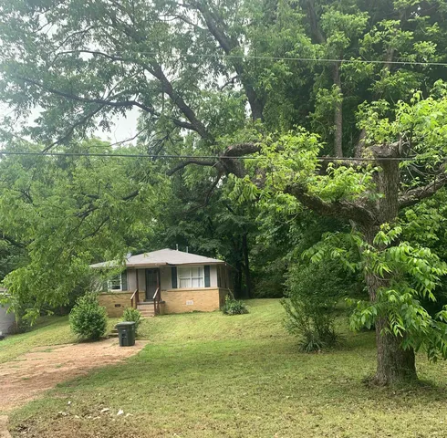 a backyard of a house with a yard and outdoor seating