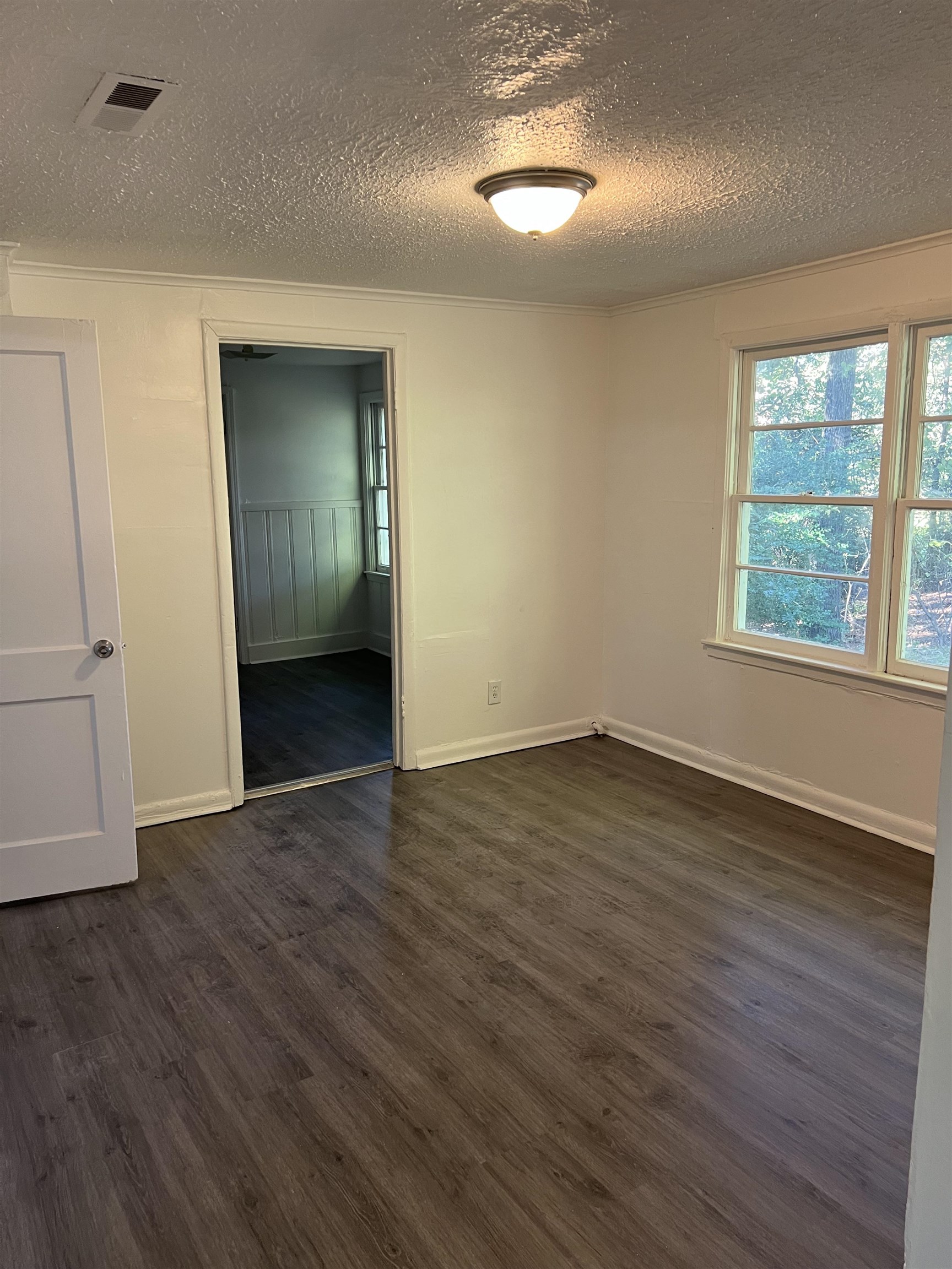 2381 Lindbergh Road Memphis, TN 38114 - Photo 3 of 10 Unfurnished bedroom featuring crown molding, dark wood finished floors, and a textured ceiling
