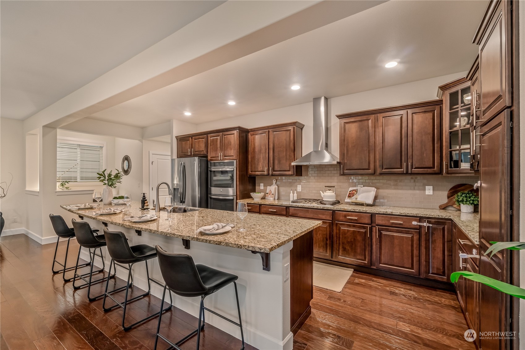 17514 39th Avenue Southeast Bothell, WA 98012 - Photo 11 of 40 a kitchen with stainless steel appliances granite countertop a table chairs sink refrigerator and cabinets