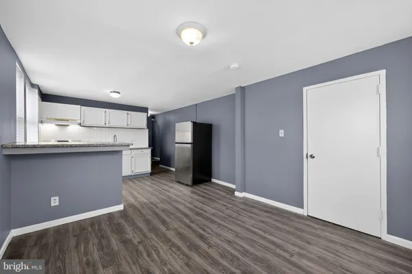a view of kitchen with refrigerator cabinet and wooden floor