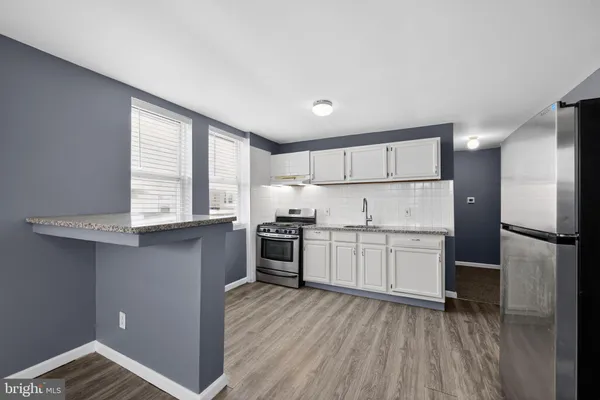 a kitchen with a refrigerator wooden floor and window