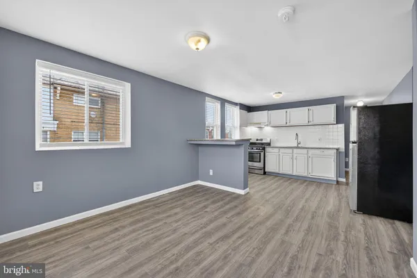 a view of kitchen with wooden floor and electronic appliances