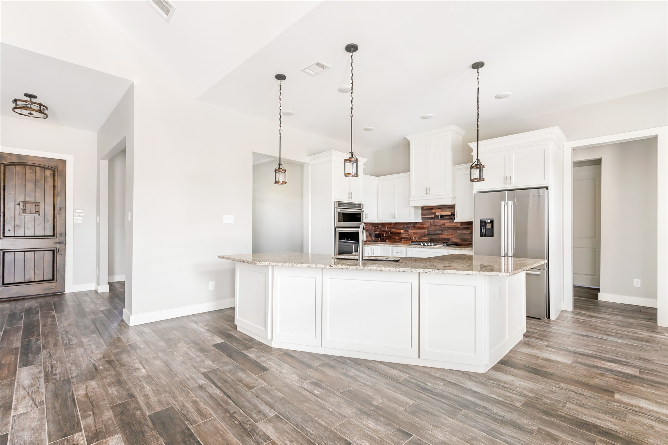 9006 Water Buck Lane Conroe, TX 77303 - Photo 31 of 48 a kitchen with kitchen island a counter top space a sink a center island and stainless steel appliances