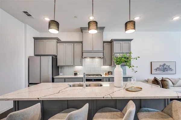 a kitchen with stainless steel appliances granite countertop a sink and white cabinets