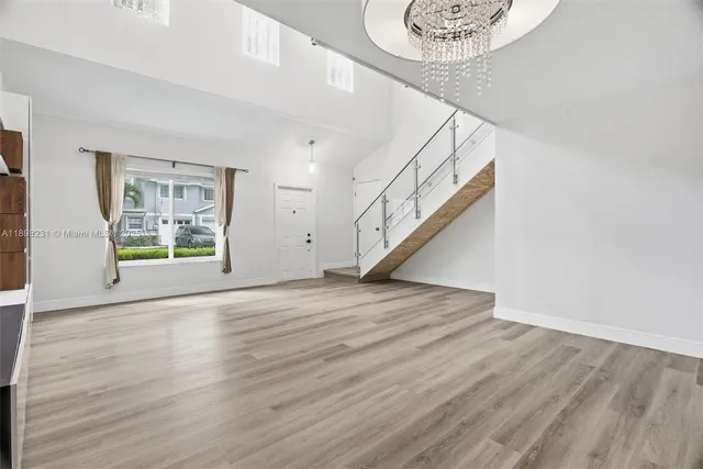 a kitchen with stainless steel appliances a refrigerator and a wooden floor