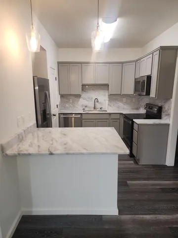 a kitchen with stainless steel appliances granite countertop a sink a stove and a refrigerator