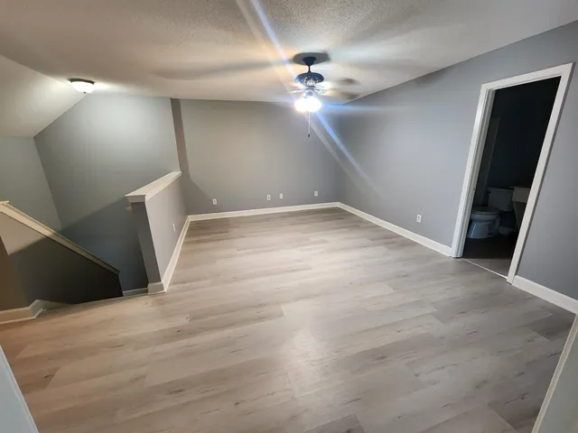 a view of an empty room with wooden floor