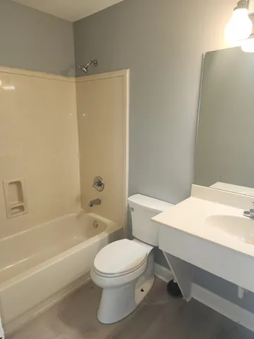 a bathroom with a white toilet sitting next to a bathroom sink and a shower