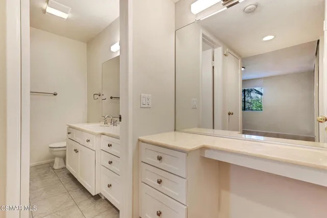 a spacious bathroom with a granite countertop sink mirror and toilet