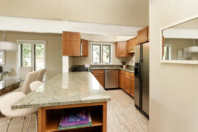 a kitchen with stainless steel appliances granite countertop a stove a sink and a refrigerator