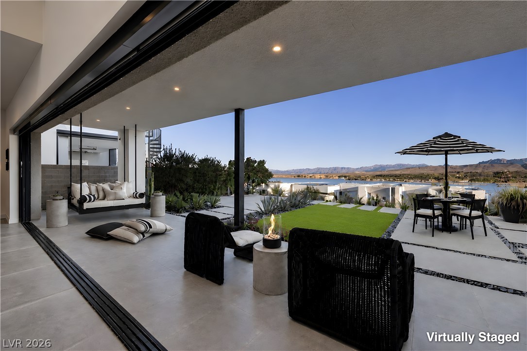 25 Falling Ridge Lane Henderson, NV 89011 - Photo 13 of 48 An inviting covered patio offers panoramic lake and mountain vistas, perfect for tranquil enjoyment.