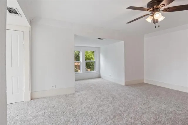 an empty room with fan and windows
