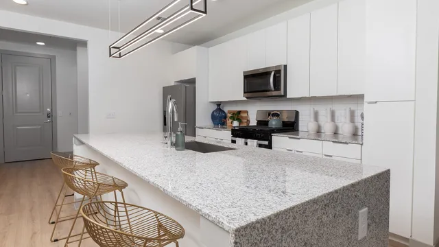 a kitchen with stainless steel appliances granite countertop a sink a stove and a refrigerator