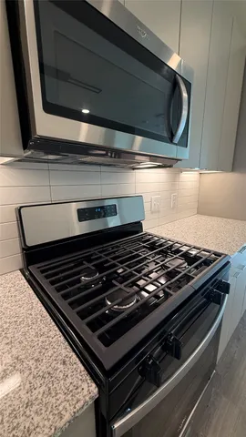 a stove sitting inside of a kitchen next to a window