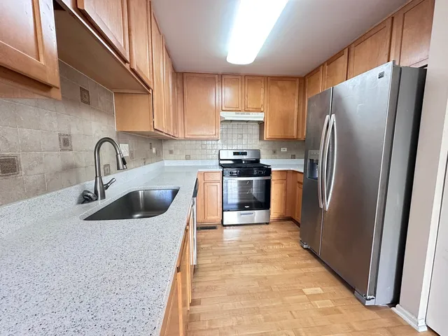 a kitchen with stainless steel appliances granite countertop a sink stove and refrigerator