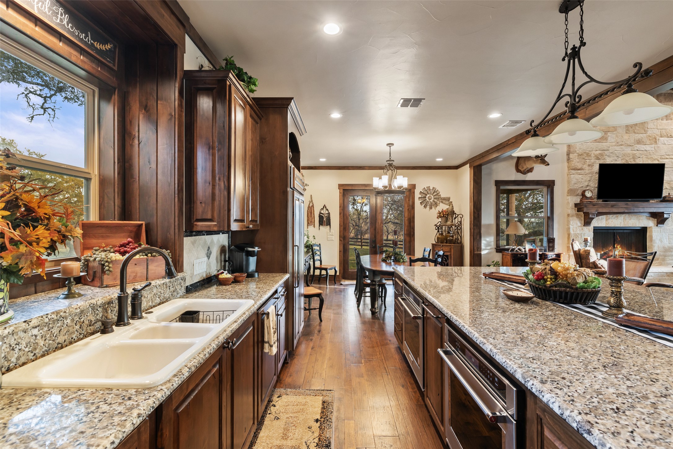 4827 Maenius Road Blanco, TX 78606 - Photo 23 of 23 Kitchen featuring dark wood finish cabinets, stainless steel oven, pendant lighting, open floor plan, and dark wood-style flooring
