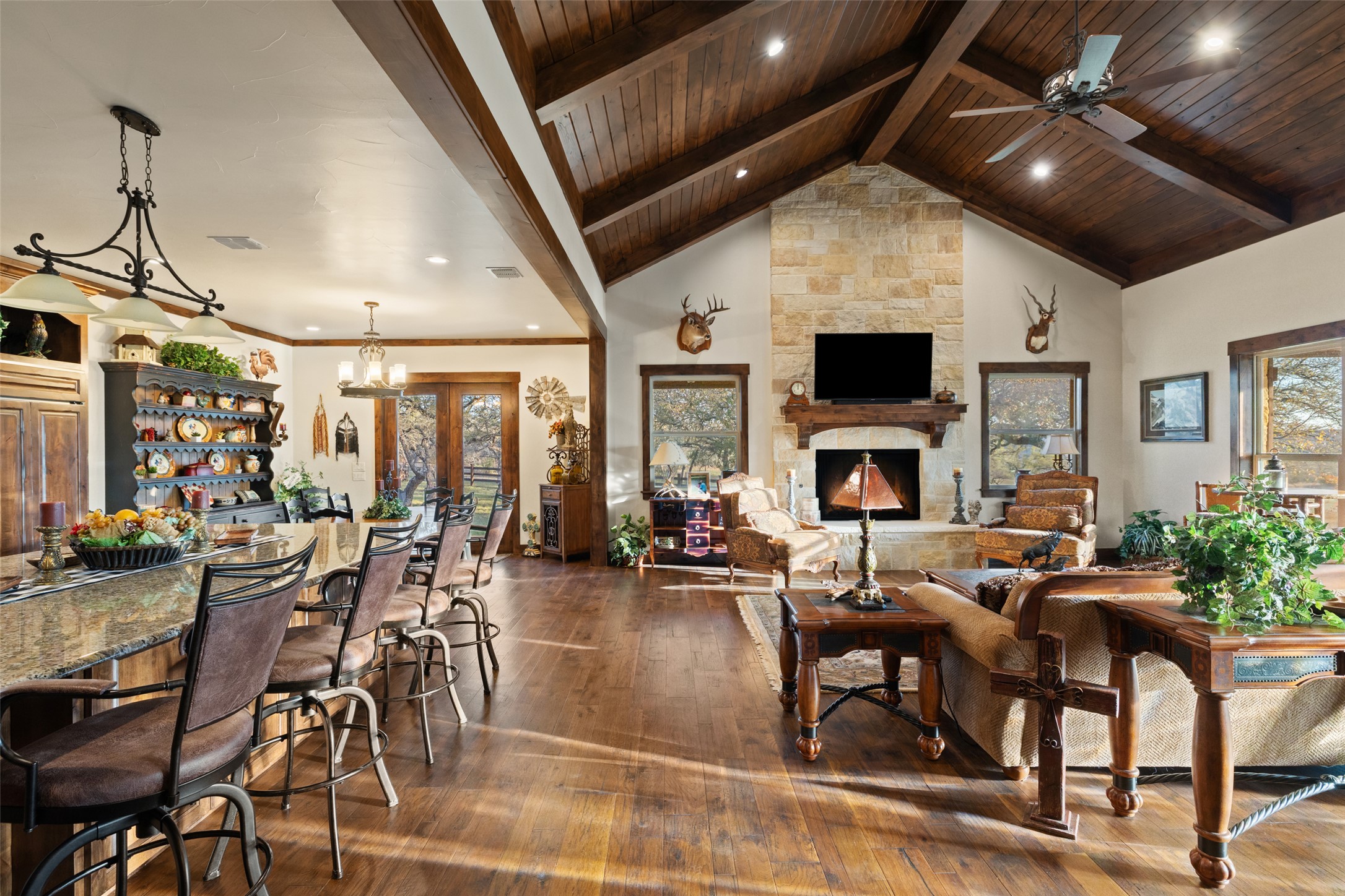 4827 Maenius Road Blanco, TX 78606 - Photo 5 of 23 Living room with dark wood finished floors, a fireplace, ceiling fan, recessed lighting, and a high wood beamed ceiling