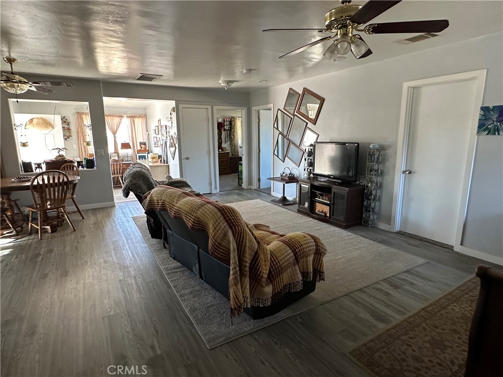 8625 C Avenue Hesperia, CA 92345 - Photo 19 of 29 a spacious bedroom with a bed a chandelier and flat screen tv