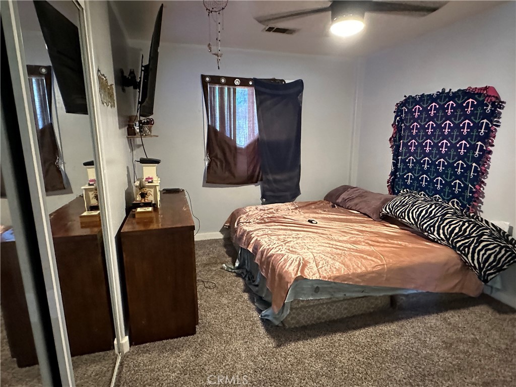 8625 C Avenue Hesperia, CA 92345 - Photo 20 of 29 a bedroom with a bed a dresser and potted plant
