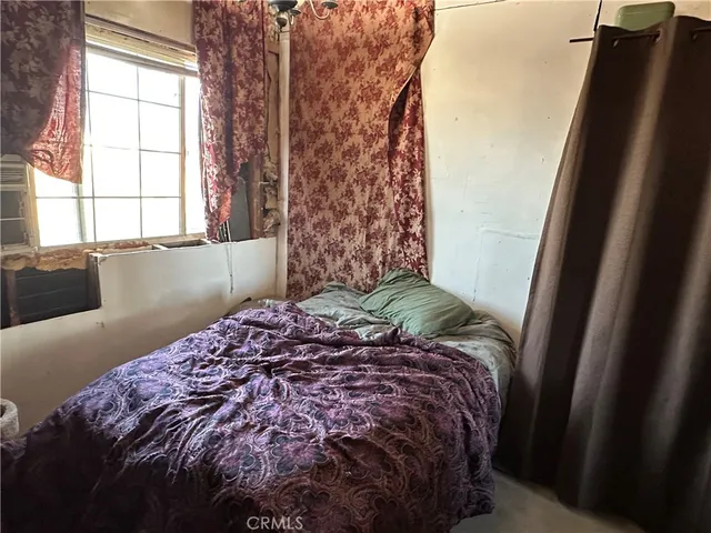 a bed sitting in a bedroom next to a window