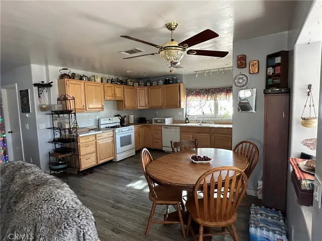 a kitchen with stainless steel appliances granite countertop a kitchen island a table and chairs