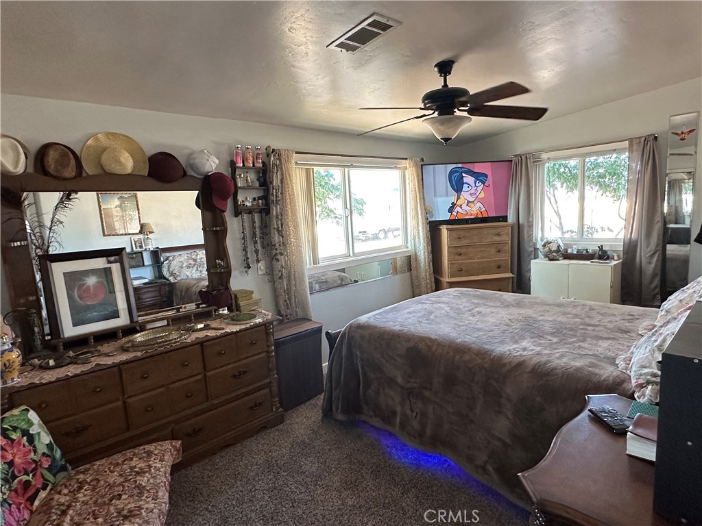 8625 C Avenue Hesperia, CA 92345 - Photo 9 of 29 a bedroom with a bed and a flat screen tv
