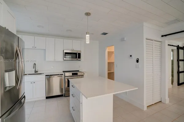 a kitchen with stainless steel appliances a refrigerator sink and microwave