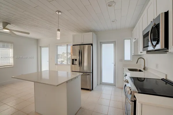 a kitchen with kitchen island a sink stove and refrigerator