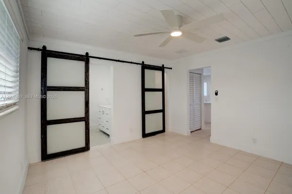 an empty room with closet and windows