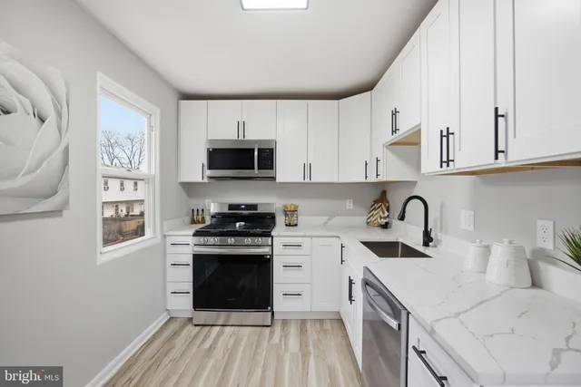a kitchen with a sink stove top oven and cabinets