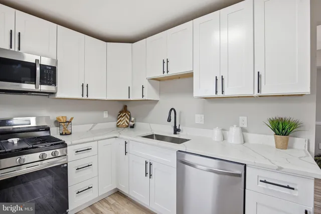 a kitchen with cabinets appliances a sink and a counter top