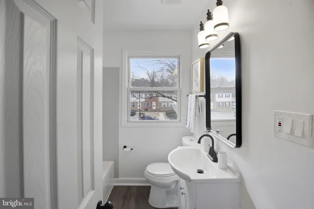a bathroom with a toilet a sink and mirror
