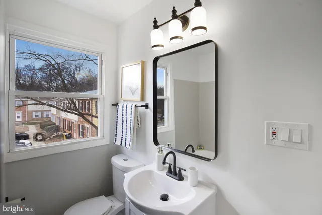 a bathroom with a toilet a sink and mirror